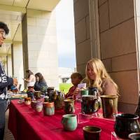 Student looking at pottery display during Student Small Business Market.